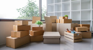 A pile of cardboard moving boxes in the corner of an empty room.